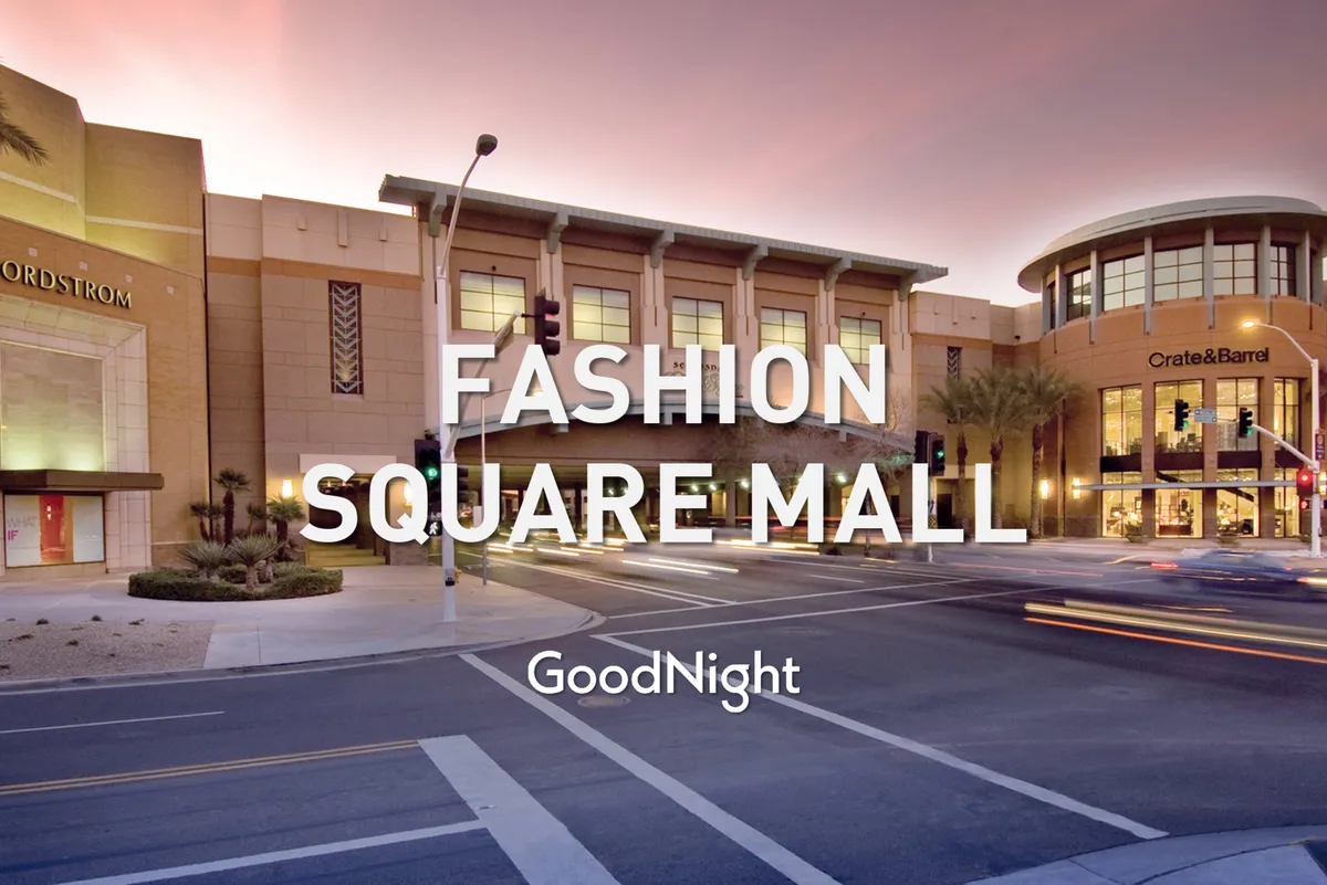 A lively exterior shot of a shopping district featuring the Nordstrom and Crate & Barrel storefronts, with palm trees and bustling traffic. The urban scene is infused with energy and accessibility, ideal for those seeking convenient access to dining, shopping, and business services.