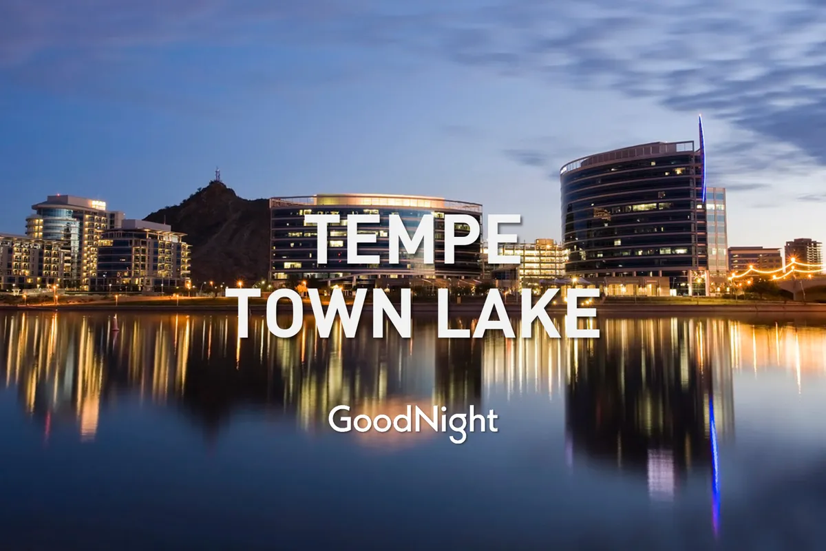 A scenic view of Tempe Town Lake bordered by modern buildings with a mountain in the background. The tranquil water and nearby cityscape capture the balance of relaxation and urban convenience, suggesting both serenity and access to major hubs.